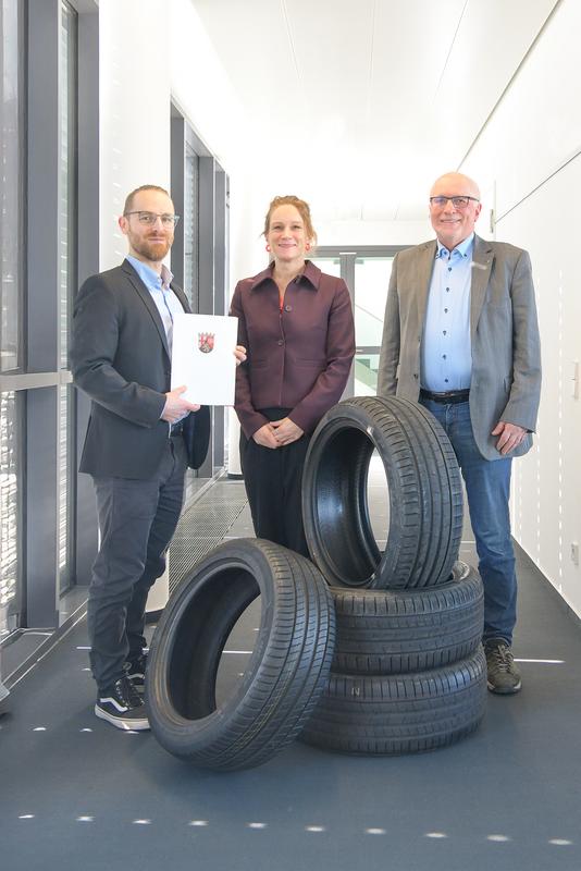 Katharina Heil, Ministerialdirektorin im rheinland-pfälzischen Wissenschaftsministerium, übergibt am Fraunhofer ITWM den Förderbescheid für das Projekt SUMERA an Stefan Thielen (links) und Klaus Dreßler (rechts), die ein digitales Modell zur Reduzierung von Reifenabrieb entwickeln.