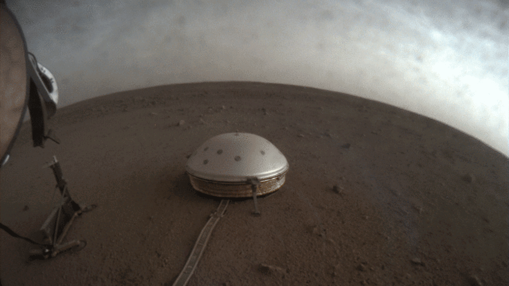 Wolken ziehen über das kuppelförmige Seismometer SEIS der NASA-Landesonde InSight auf dem Mars. © NASA/JPL-Caltech 