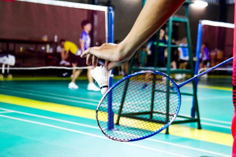 vecteezy_the-badminton-player-holding-a-white-shuttlecock-and-racket_44158063