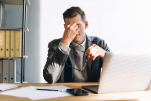 Modern man with glasses, office worker tired at work