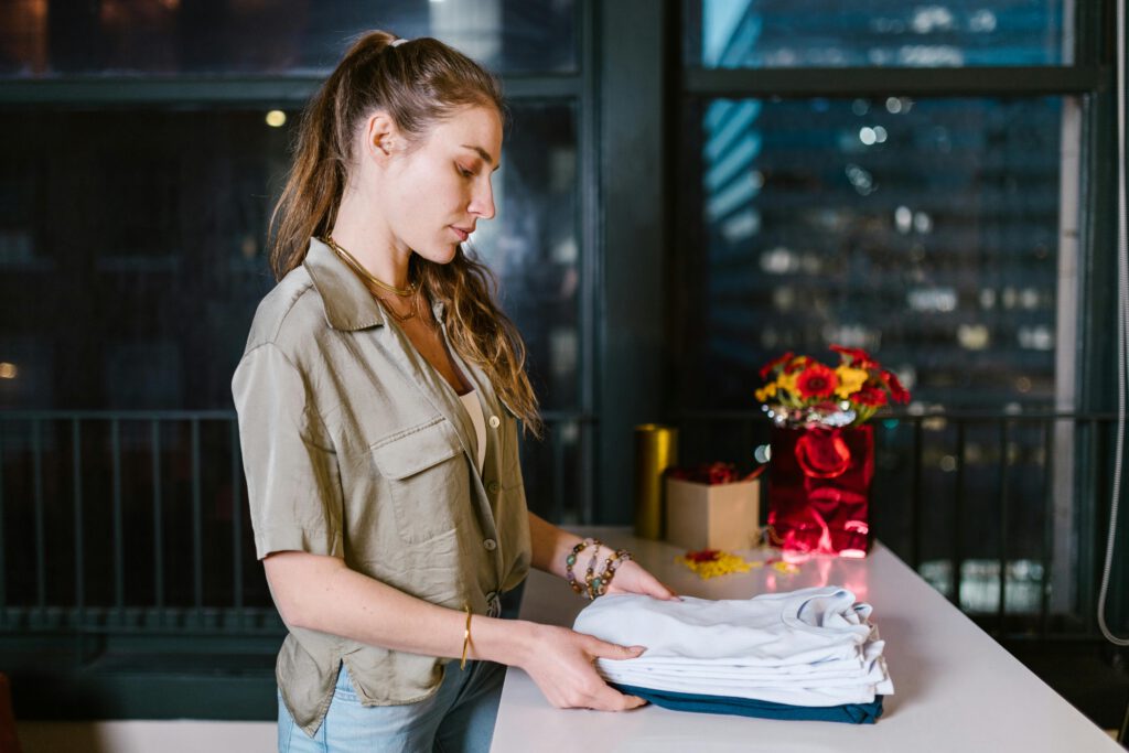 Eine Frau faltet T-Shirts präzise nach Farben sortiert – für manche eine harmlose Gewohnheit, für andere ein Hinweis auf tief verwurzelte Routinen.