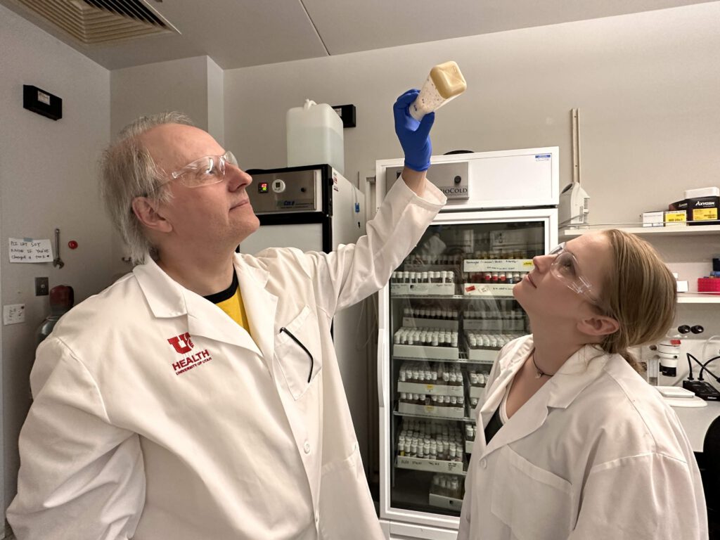 Adrian Rothenfluh (links) und Pearl Cummins-Beebee (rechts) begutachten im Labor eine Flasche mit Fruchtfliegen. © Caitlyn Harris / University of Utah Health