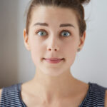 Frau blickt mit großen Augen in die Kamera