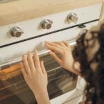 Frau schaut in den Ofen