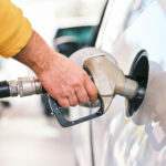 Mann tankt ein weißes Auto