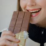 Frau beißt in Schokolade
