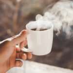 Dampfender Kaffee in der Hand