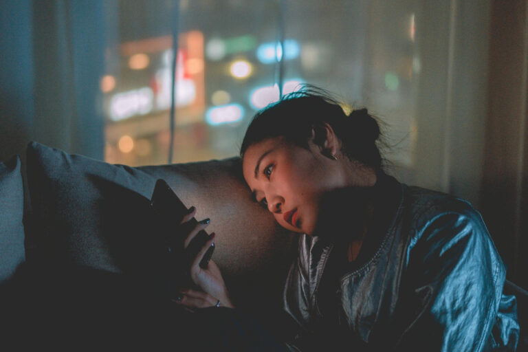 Frau am Handy auf der Couch