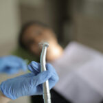 Zahnarzt hält einen Bohrer hoch