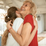 Eine jüngere und eine ältere Frau umarmen sich