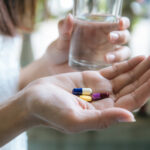 Frau hält Pillen in der Hand