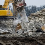 Ein Abrissbagger zerlegt ein Gebäude