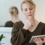 Frau mittleren Alters schaut aufs Tablet