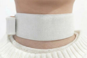 Eine weiße Halsmanschette am Hals einer Person.