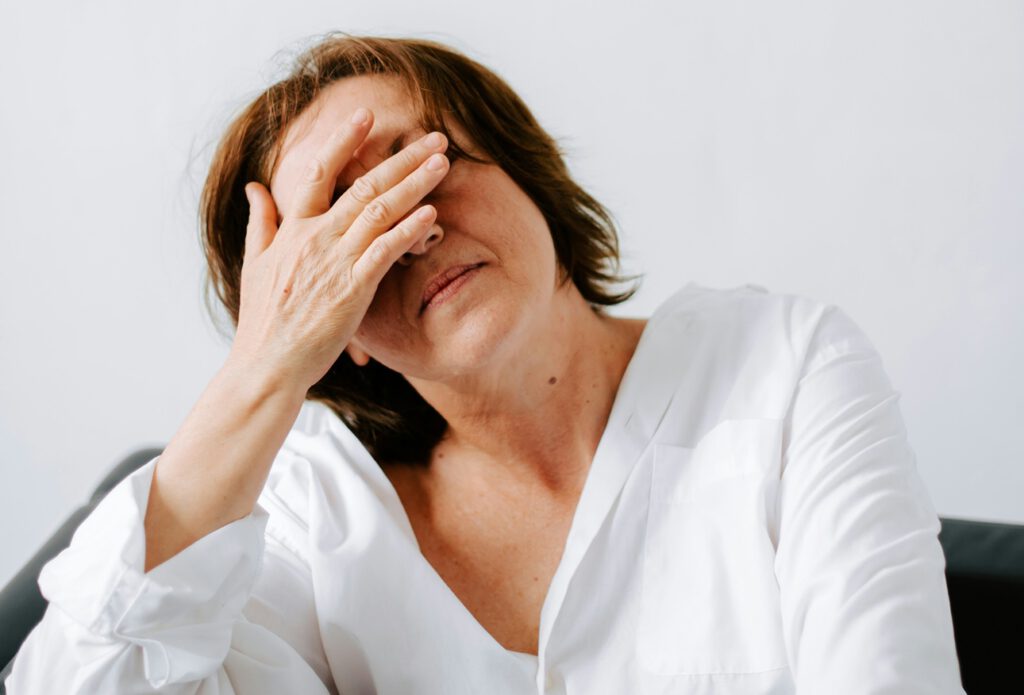 Frau fasst sich an den Kopf