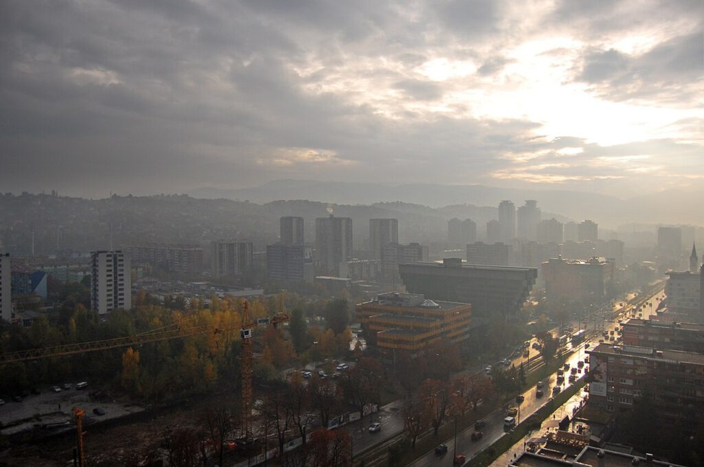 Smog liegt über der Stadt: Rauch und Schadstoffe stauen sich im engen Tal, die Luftqualität verschlechtert sich deutlich.