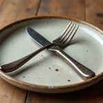 Teller mit Messer und Gabel gekreuzt