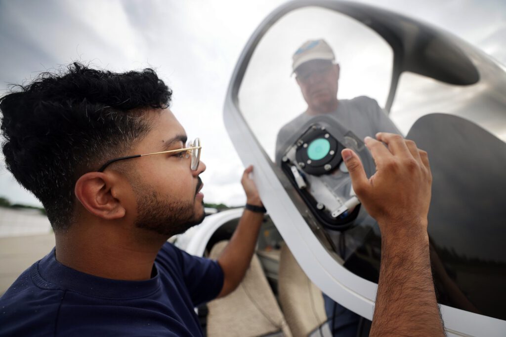 Rohan Madathil arbeitet gemeinsam mit Entwicklungsleiter Nilton Renno an einem Sensor für gefrierenden Regen, während sie ein Flugzeug für einen Testflug bei bewölktem Himmel vorbereiten. © Brenda Ahearn/University of Michigan