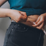 Frau misst ihren Bauch