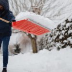 Mann beim Schneeschippen