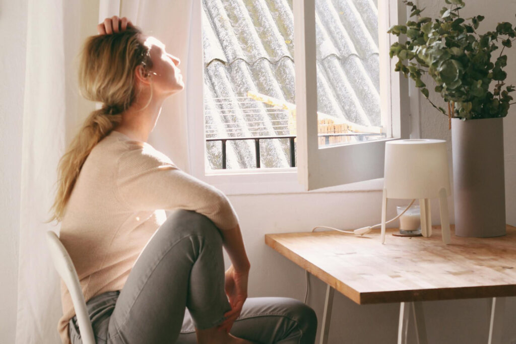 Frau hält morgens ihr Gesicht in die Sonne