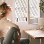 Frau hält morgens ihr Gesicht in die Sonne