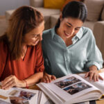 Zwei Frauen blättern in einem Fotoalbum