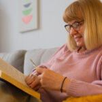 Ältere Frau liest auf dem Sofa
