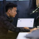 Junger Chinese mit Laptop