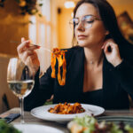 Junge Frau isst Pasta