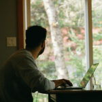 Ein Mann arbeitet im Homeoffice am Küchentisch