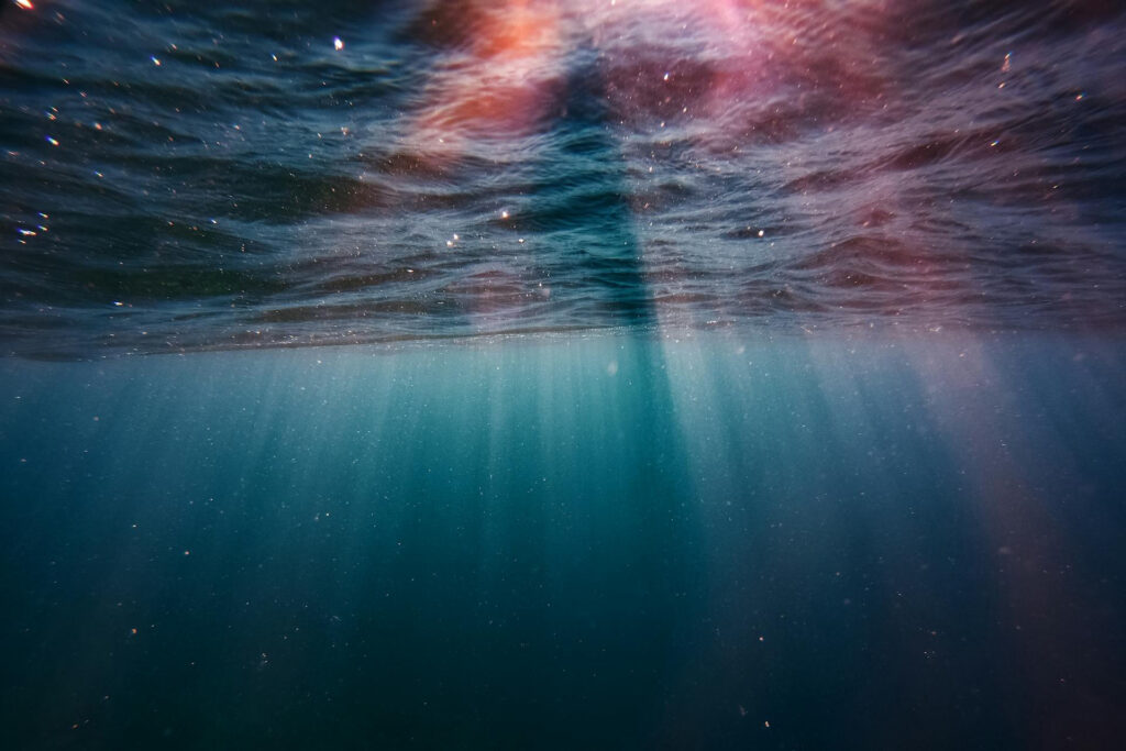 Sonnenstrahlen unter einer Wasseroberfläche.