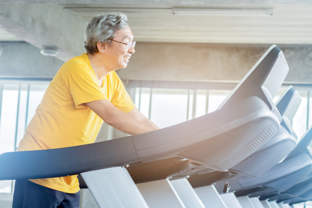 Älterer asiatischer Mann auf dem Laufband