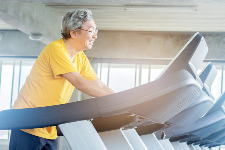 Älterer asiatischer Mann auf dem Laufband