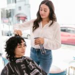 Eine Friseurin kämmt die Haare einer Kundin.