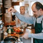 Mann bereitet Essen mit einer Pfanne zu