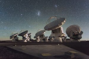 Unter einem funkelnden Sternenhimmel suchen die ALMA-Antennen in Chile nach Signalen aus bislang kaum erforschten Bereichen des Radiospektrums.