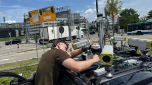 Autos, die um Ecken sehen können: TUM-Forscher Erik Leo Haß überprüft die Sensoren eines Testfahrzeugs an einer Kreuzung in Garching-Hochbrück. © Schmitz/TUM