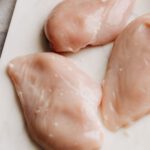 Rohes Hähnchen kann Campylobacter tragen, die sich beim Zubereiten leicht in der Küche verbreiten. Violett-blaues Licht soll die Keimbelastung künftig schon in der Verarbeitung deutlich senken.