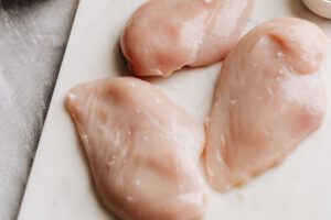 Rohes Hähnchen kann Campylobacter tragen, die sich beim Zubereiten leicht in der Küche verbreiten. Violett-blaues Licht soll die Keimbelastung künftig schon in der Verarbeitung deutlich senken.