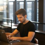 Mann sitzt am Laptop