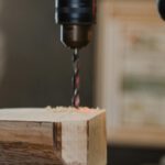 Eine Maschine bohrt ein Loch in einen Holzblock. © Pexels