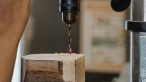 Eine Maschine bohrt ein Loch in einen Holzblock. © Pexels
