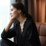 Junge Frau schaut aus dem Fenster