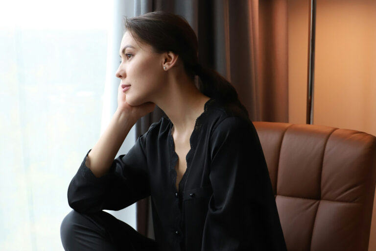 Junge Frau schaut aus dem Fenster