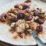 Haferbrei mit Tiefkühlbeeren, Nüssen und Zimt: Ein einfaches Frühstück liefert Ballaststoffe, Vitamine und gesunde Fette – ohne teure Spezialprodukte.