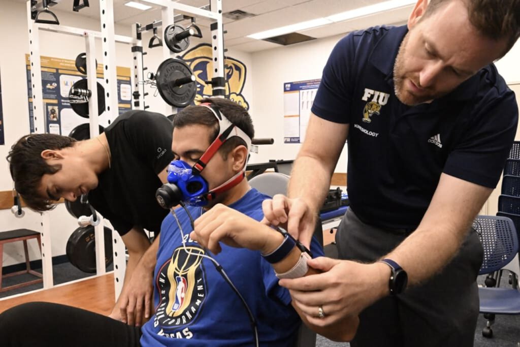 Wie genau misst die Smartwatch wirklich? FIU-Forscher Jason Kostrna legt einem Teilnehmer die Uhr an, während ein Stoffwechselmessgerät den tatsächlichen Kalorienverbrauch erfasst. © Taimy Alvarez / Florida International University