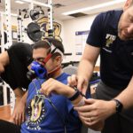 Wie genau misst die Smartwatch wirklich? FIU-Forscher Jason Kostrna legt einem Teilnehmer die Uhr an, während ein Stoffwechselmessgerät den tatsächlichen Kalorienverbrauch erfasst. © Taimy Alvarez / Florida International University