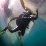 Handarbeit gegen Biofouling: Taucherin Isabell Hentschel reinigt die Mesokosmen unter Wasser, damit der natürliche Lichteinfall erhalten bleibt. © Micha Sswat, GEOMAR