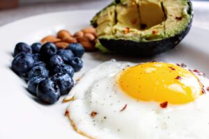 Spiegelei, Avocado und Blaubeeren passen zu einer kohlenhydratarmen Ernährung. In der Studie war die Keto-Kost allerdings deutlich strenger zusammengesetzt.